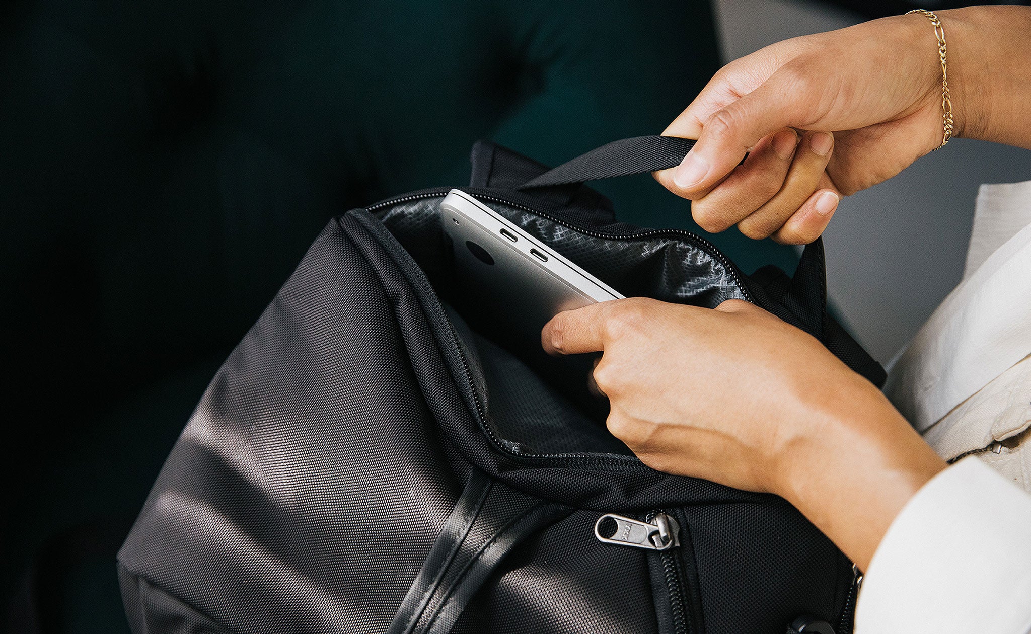 Person putting a laptop in the laptop compartment of the Aeronaut 30.